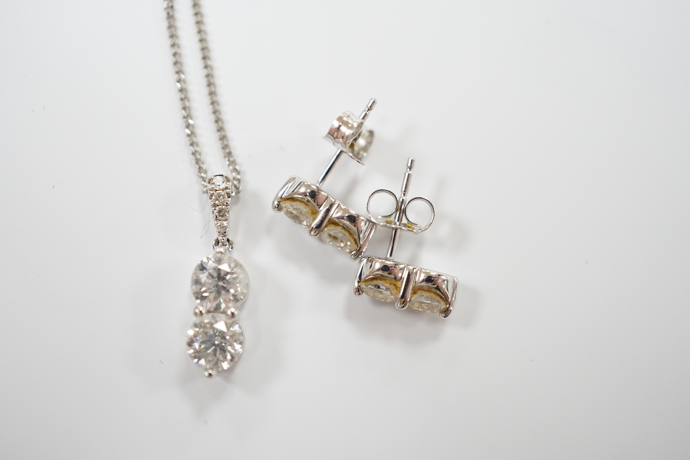 A modern 14k gold and two stone diamond set pendant, with diamond chip set bale, on a 14k gold fine link chain